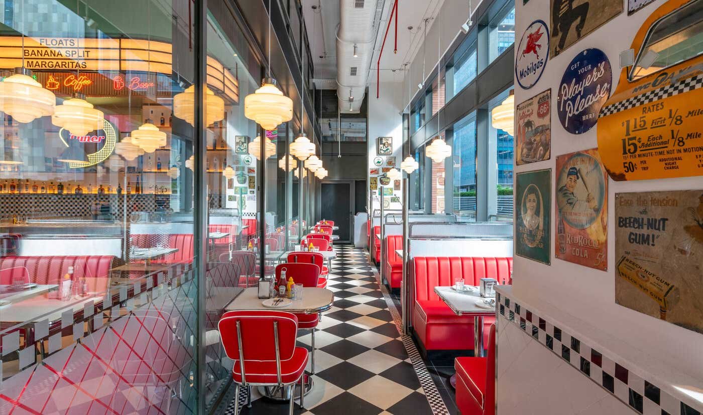 Red booths, checkerboard floor and a wall of vintage American plaques.
